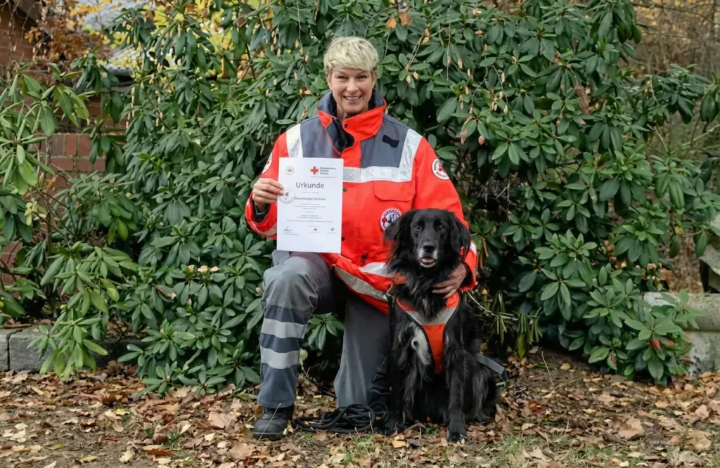 Sabine Reincke nach einer bestandenen DRK Maintrailer Prüfung mit ihrem Hund Dexter.